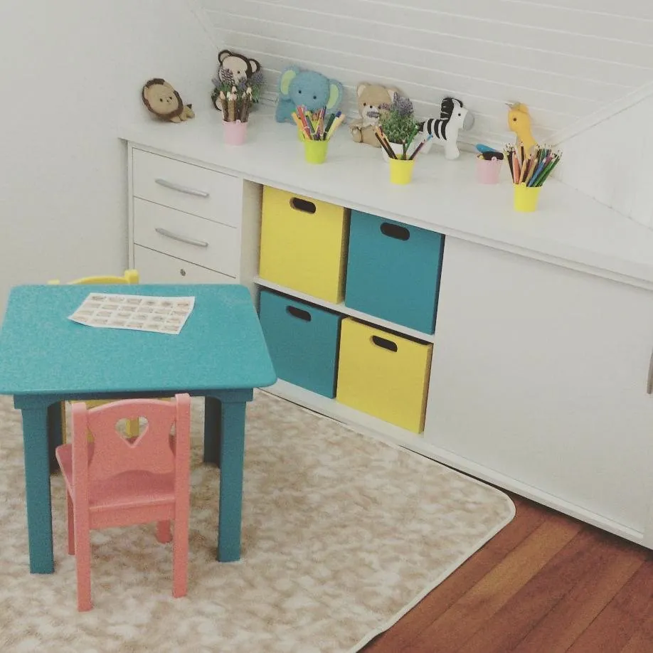 Sala de atendimento infantil com mesinha, cadeirinhas coloridas e brinquedos
